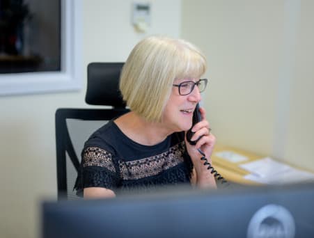 A volunteer opportunity provider sitting at a desk with a laptop.